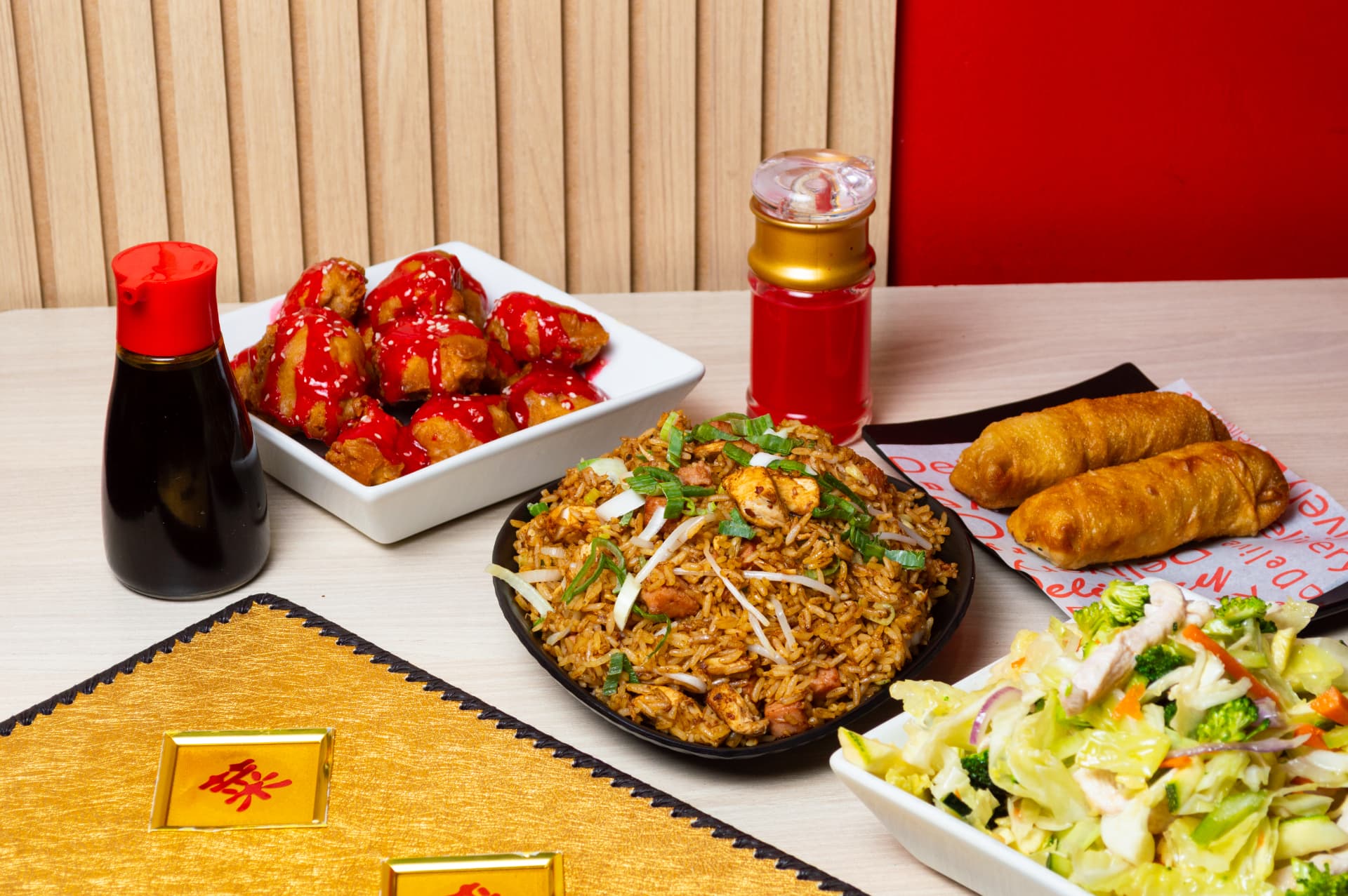 Chaufa, pollo agridulce y lumpias servidos en mesa