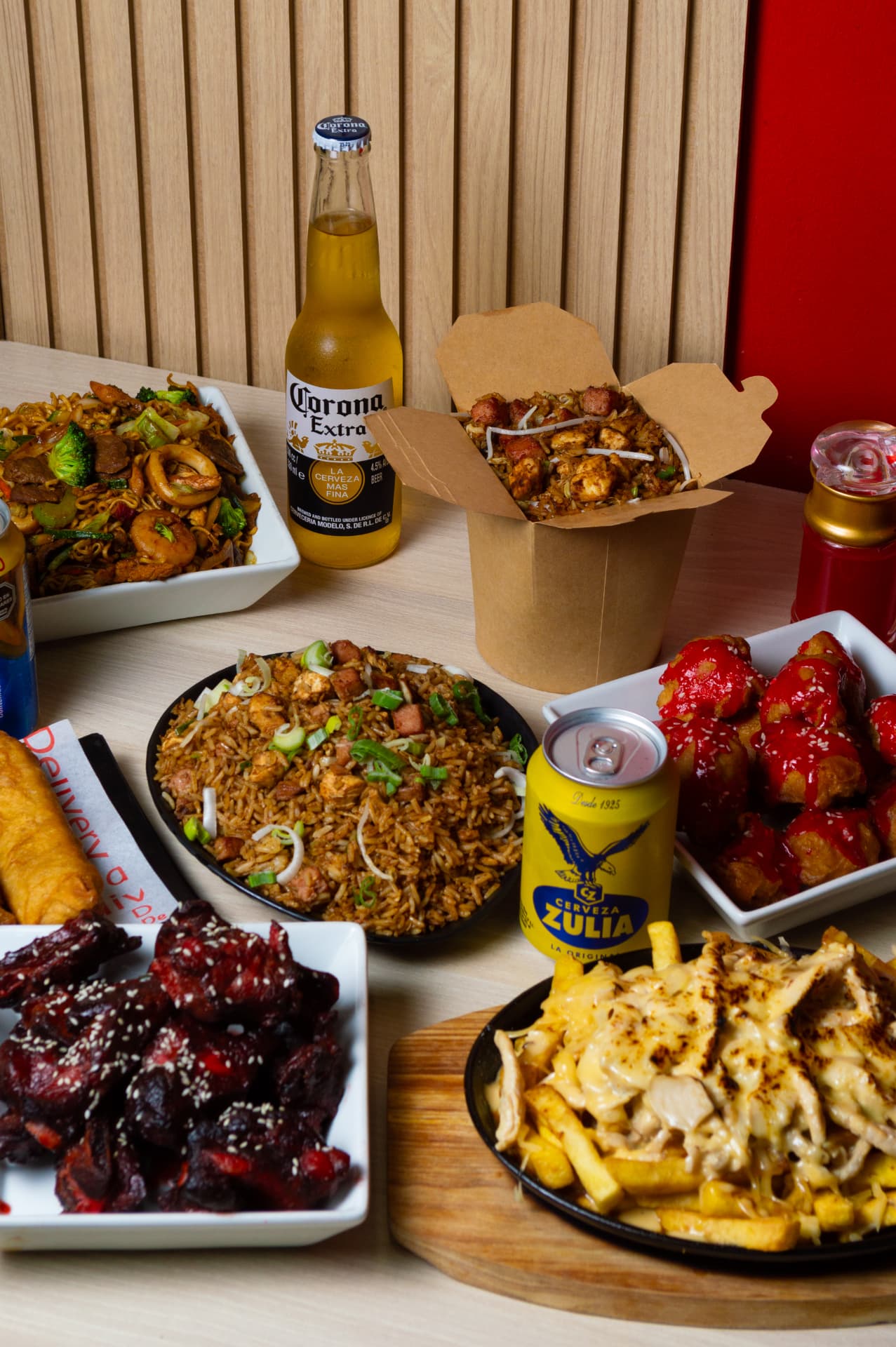 Mesa con chaufa, chow mein, alitas y cervezas